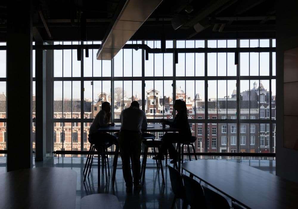 Team meeting in modern office with large windows and city view